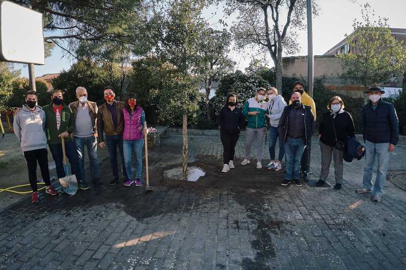 Personas miran a cámara tras plantar un árbol en Moralzarzal