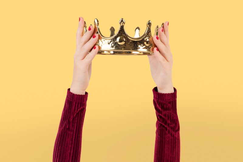 Unas manos de mujer sujetan una corona